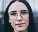 Portrait image of female wearing glasses whilst outside