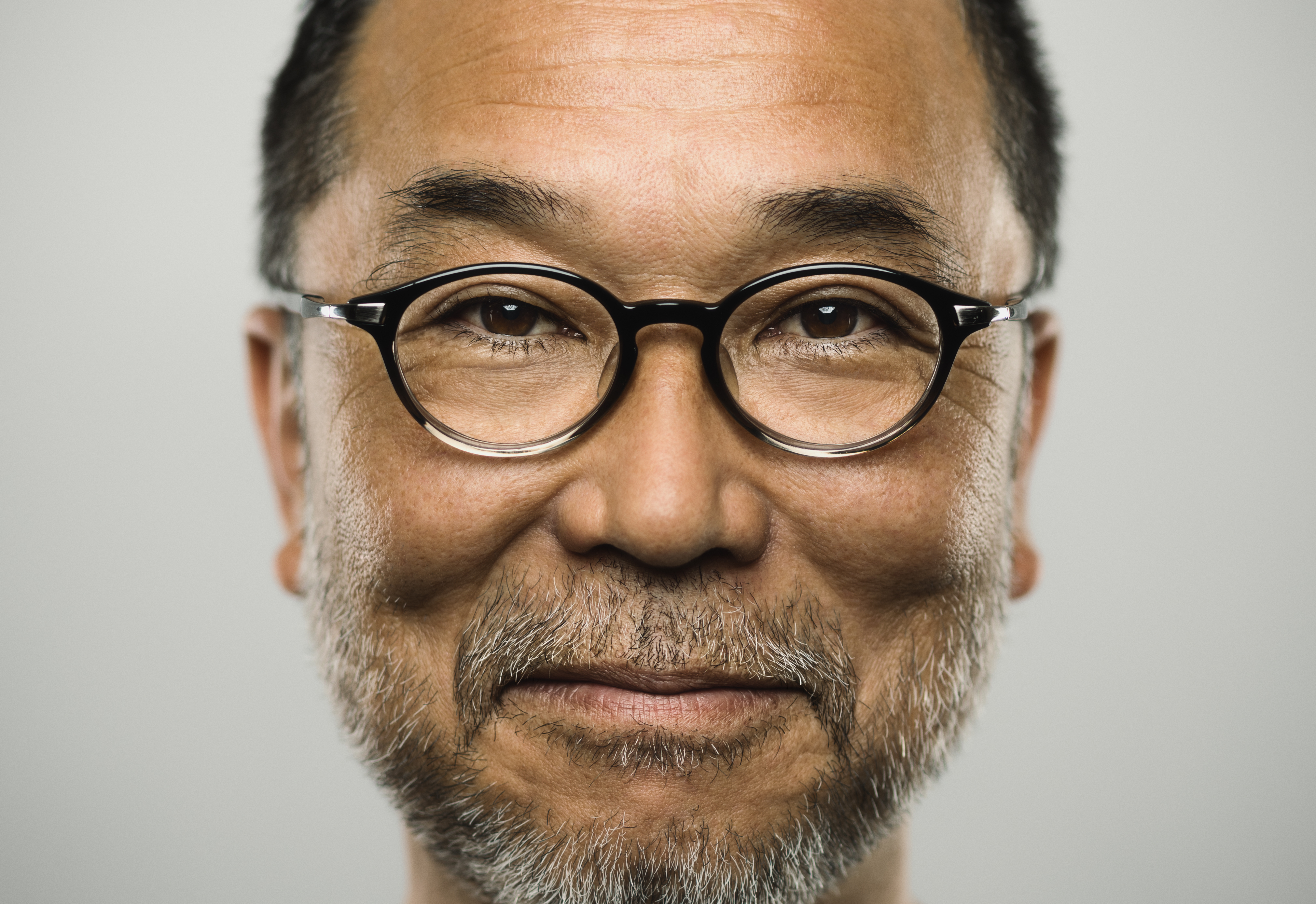 Close up image of males wear glasses on a grey background